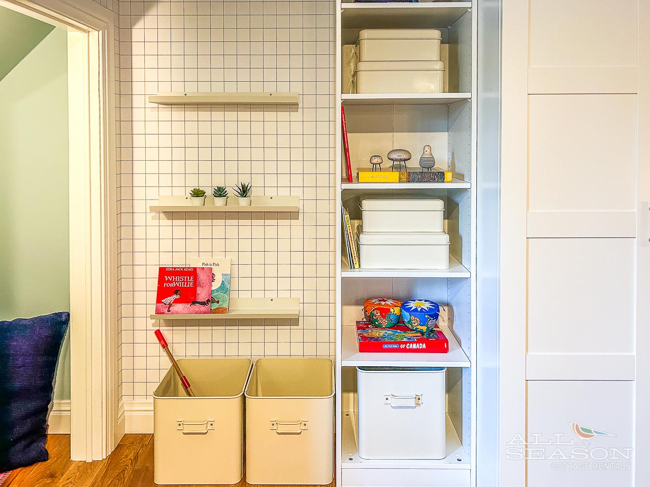 Your thoughtfully organized shelving keeps everything perfectly tidy, with handy storage boxes and colorful touches making the space feel both functional and welcoming.