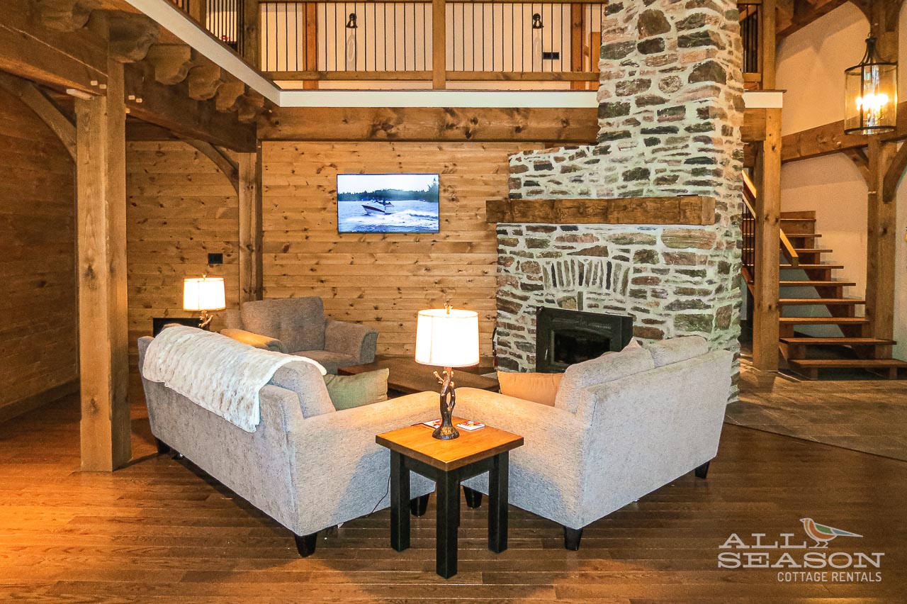 Sink into plush seating beside your stone fireplace, where warm wood beams and rustic charm create the perfect retreat atmosphere.