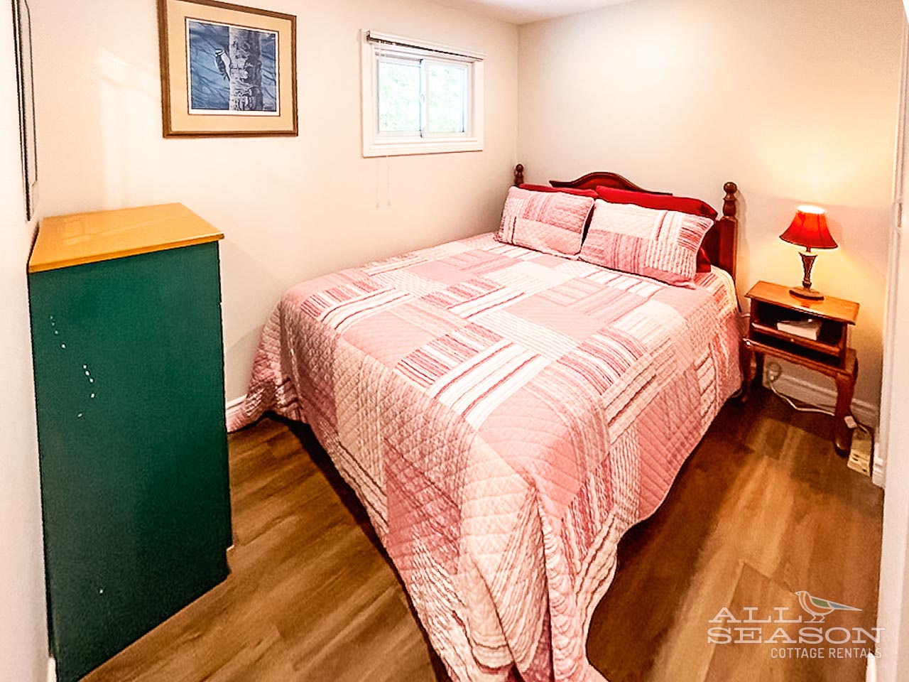 Sink into comfort in this cozy bedroom featuring warm wood floors, soft natural light, and thoughtful touches for your peaceful retreat.