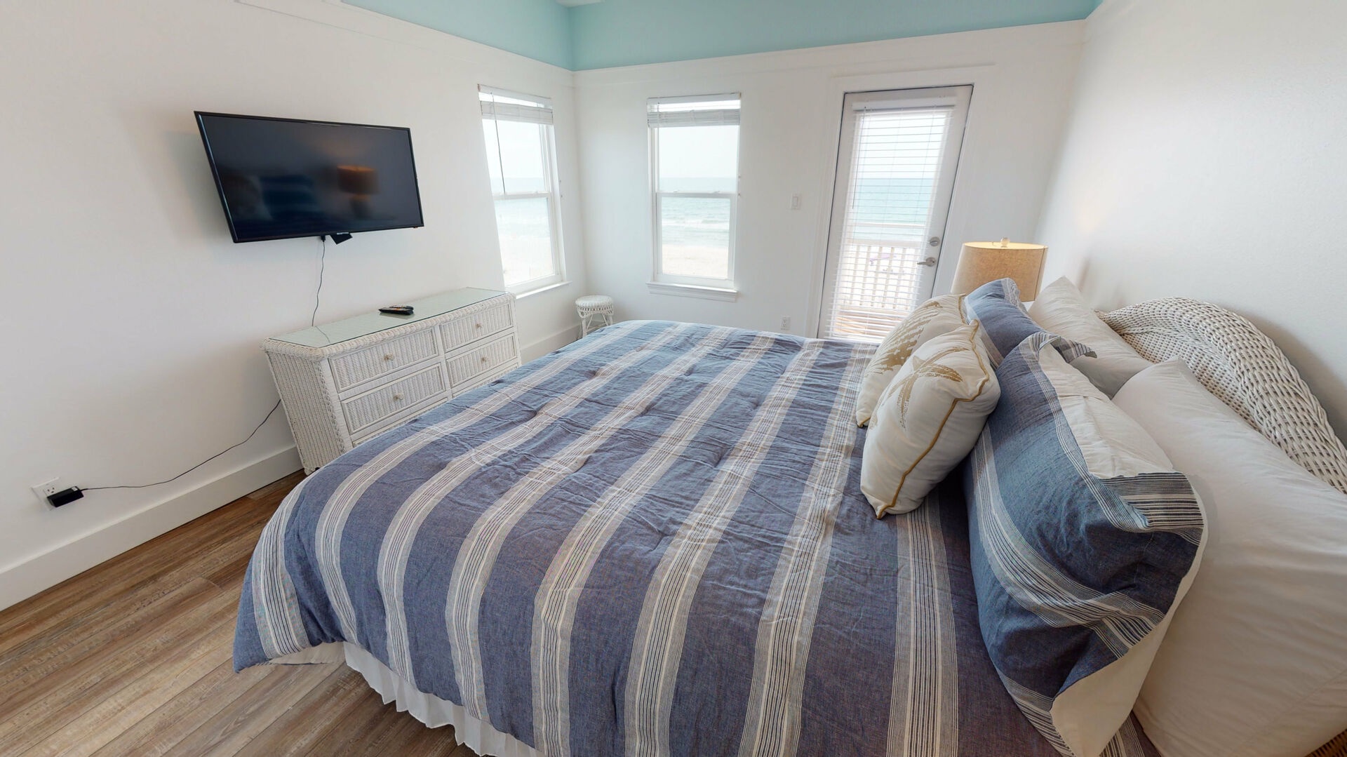 Bedroom 4 located upstairs features a king bed, TV with cable, access to the balcony with beach views and an attached, private bathroom