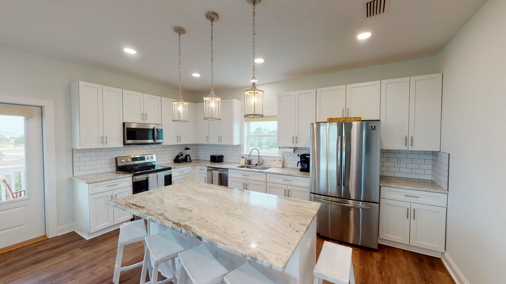 Open kitchen with 5 bar stools and a large Island for everyone to gather around. Stainless steel appliances