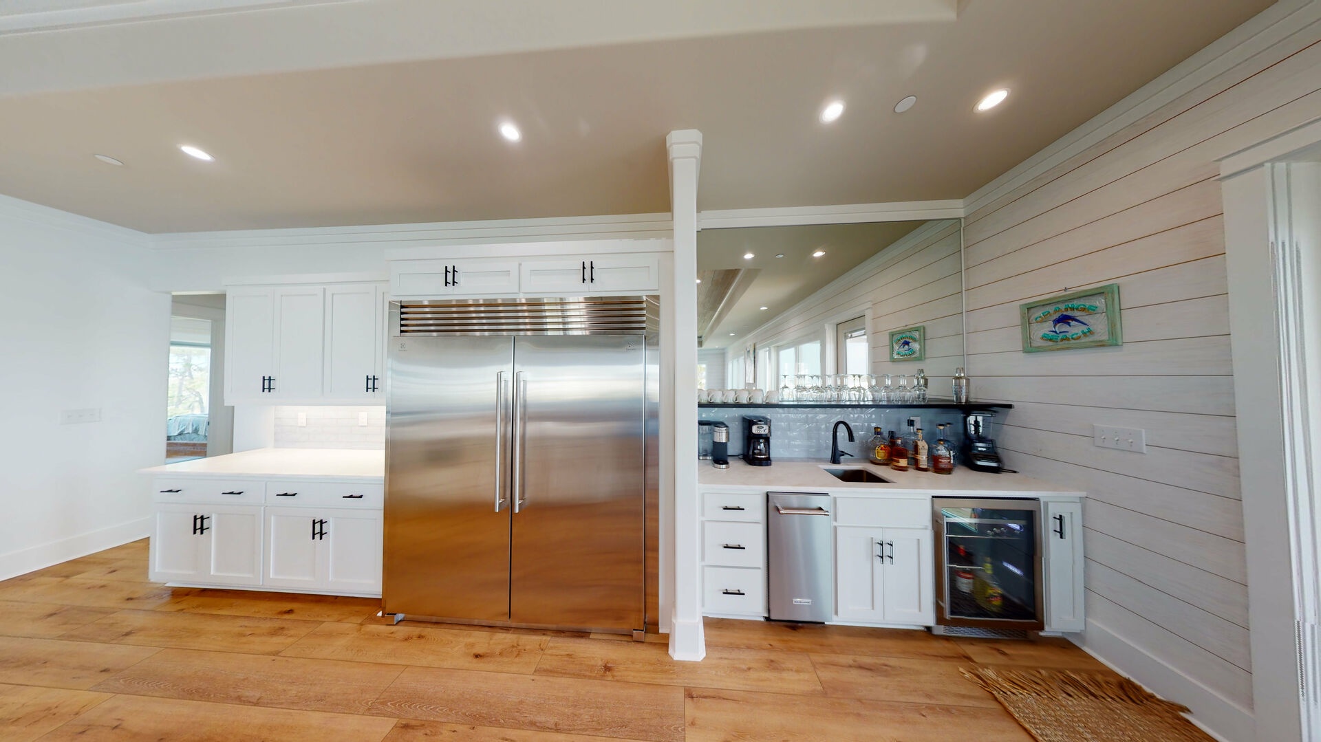 The kitchen has a large commercial refrigerator, wet/coffee bar, dedicated ice maker and a wine fridge