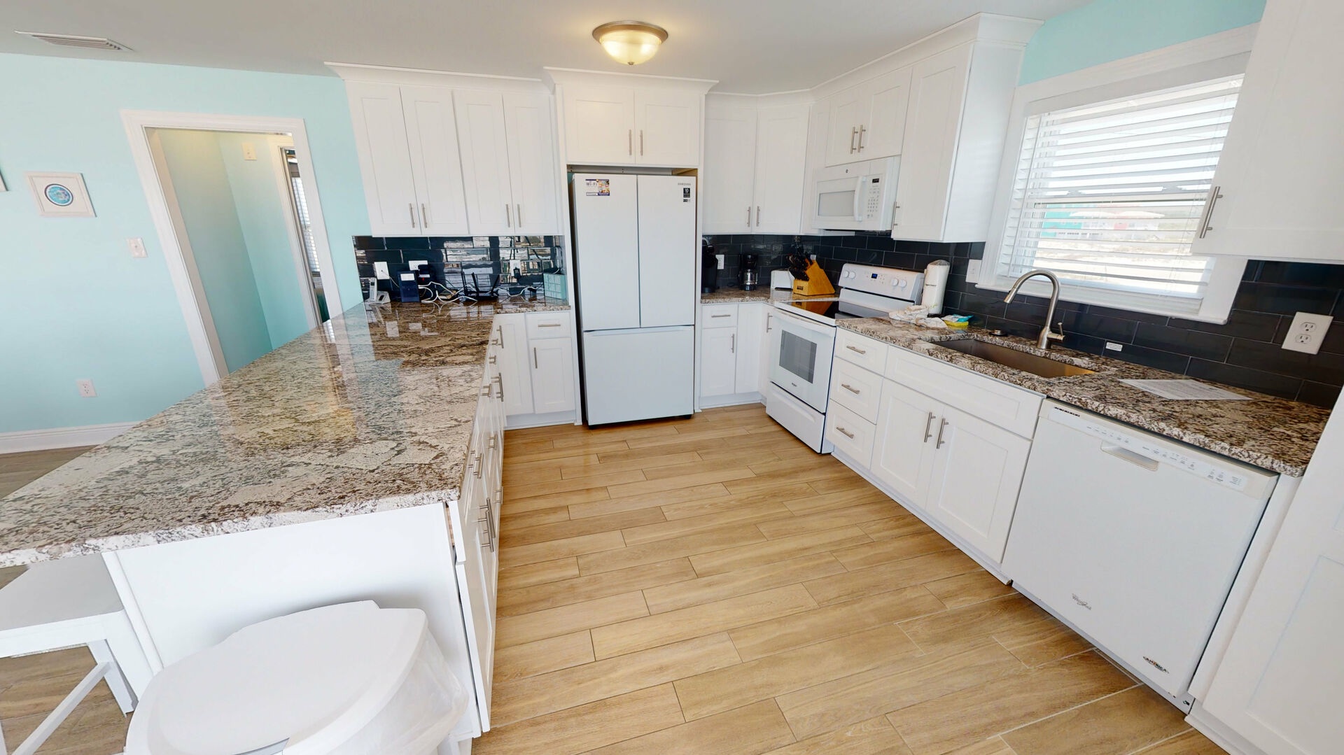 Spacious kitchen with granite countertops, significant counter space, and bar seating for 4
