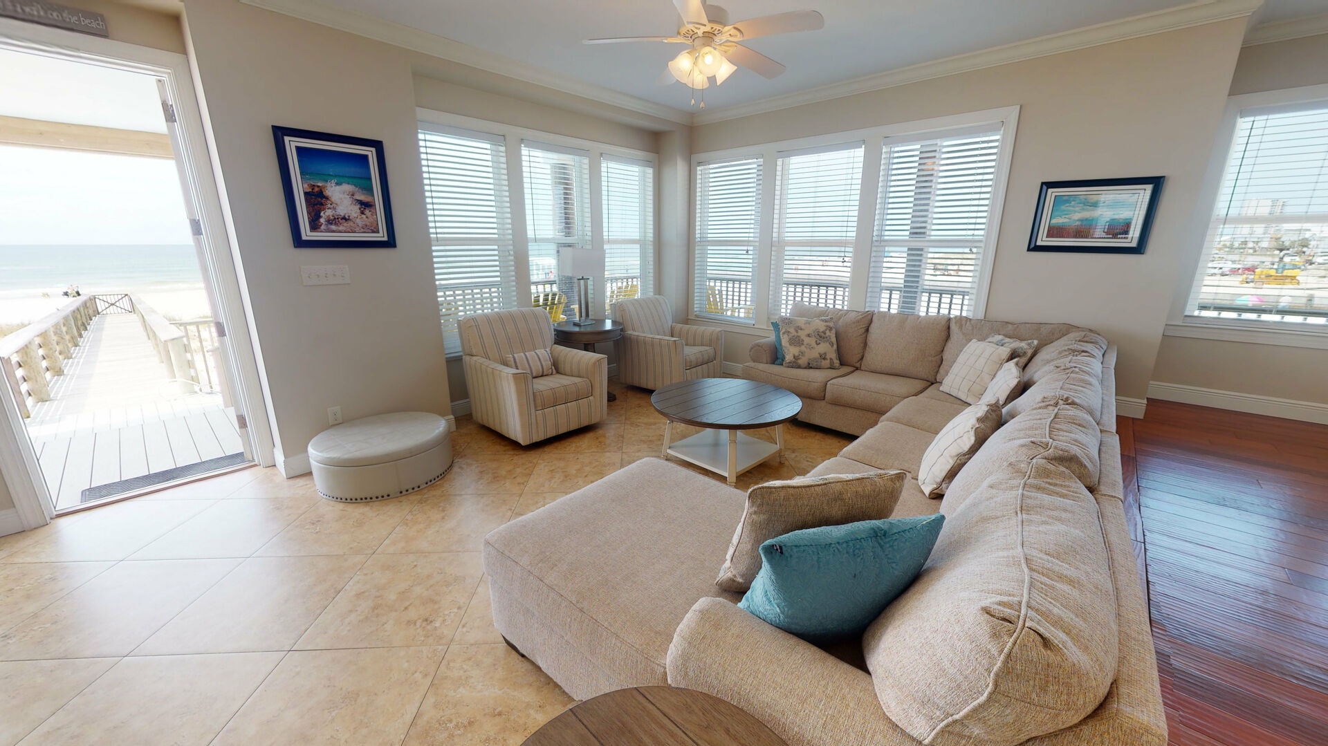 Bright and spacious living area with a large sectional and access to the beach