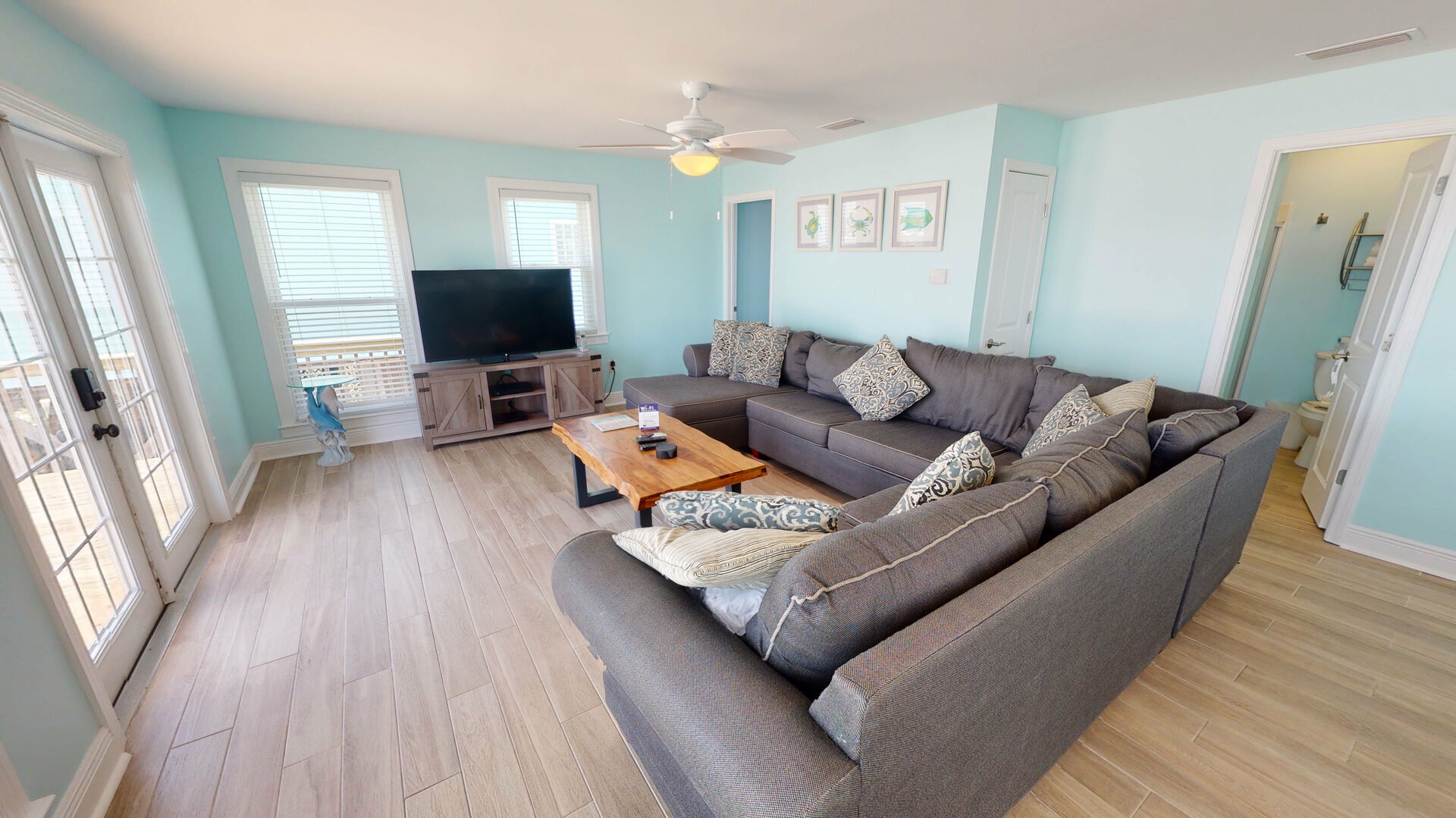 Living area features a large sectional that also doubles as a sofa sleeper for 2, TV, and access to the beach front deck