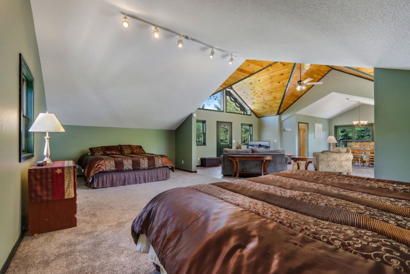 Your spacious loft bedroom features soaring vaulted ceilings with warm wood beams and twin beds perfect for family getaways.