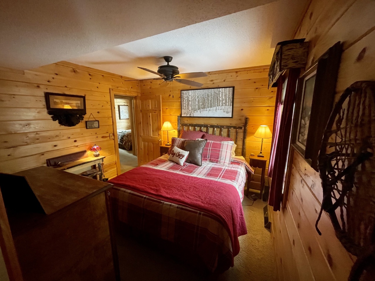 Cozy cabin bedroom with warm pine walls and rustic charm awaits your mountain retreat.