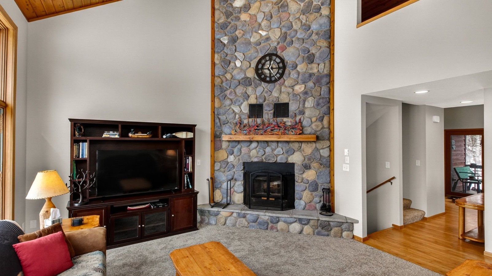 Cozy up by your stunning stone fireplace while watching your favorite shows on the entertainment center in this warm, inviting living space.