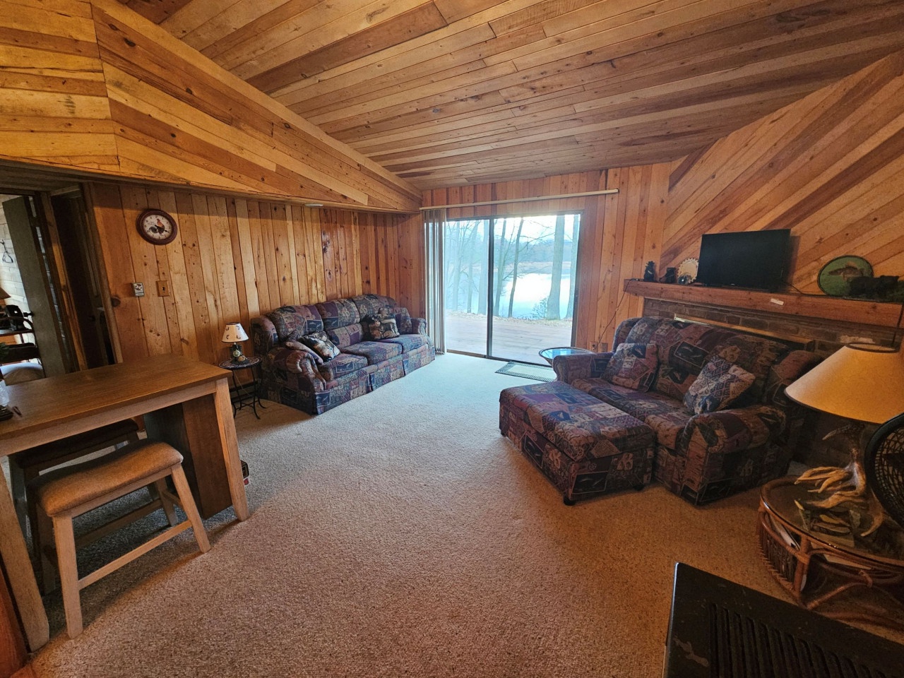 Cozy up in this rustic living room where exposed wood beams and stone fireplace create your perfect retreat for evening conversations.