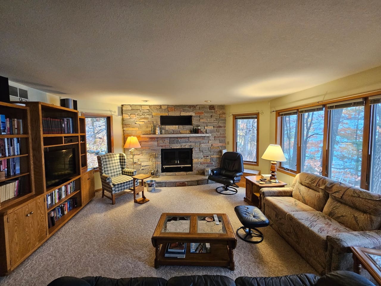 Cozy up in your spacious living room with stone fireplace, library nook, and forest views through every window.