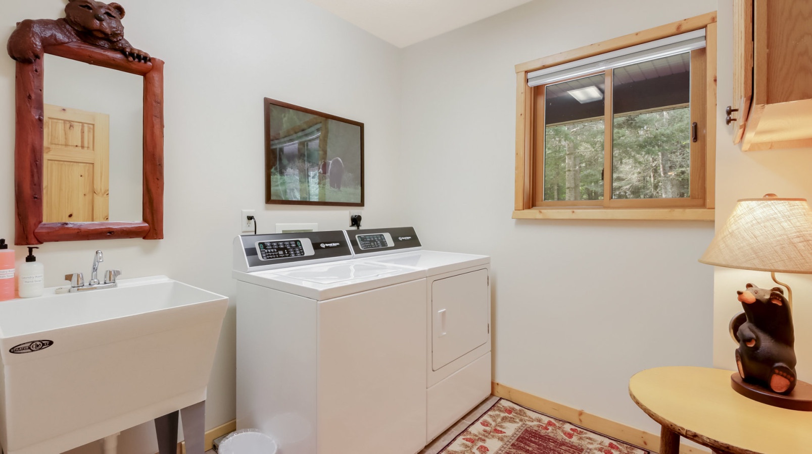 Your dedicated laundry room combines convenience with rustic charm, featuring a utility sink and full washer-dryer setup.