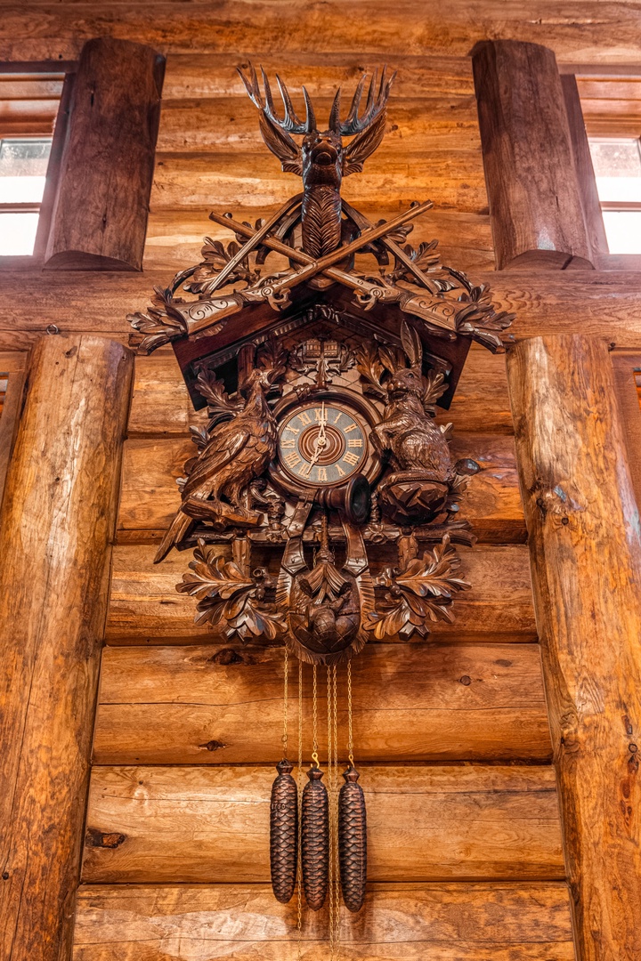 This ornate cuckoo clock adds authentic charm to your rustic retreat, its intricate woodwork perfectly complementing the warm log cabin ambiance.