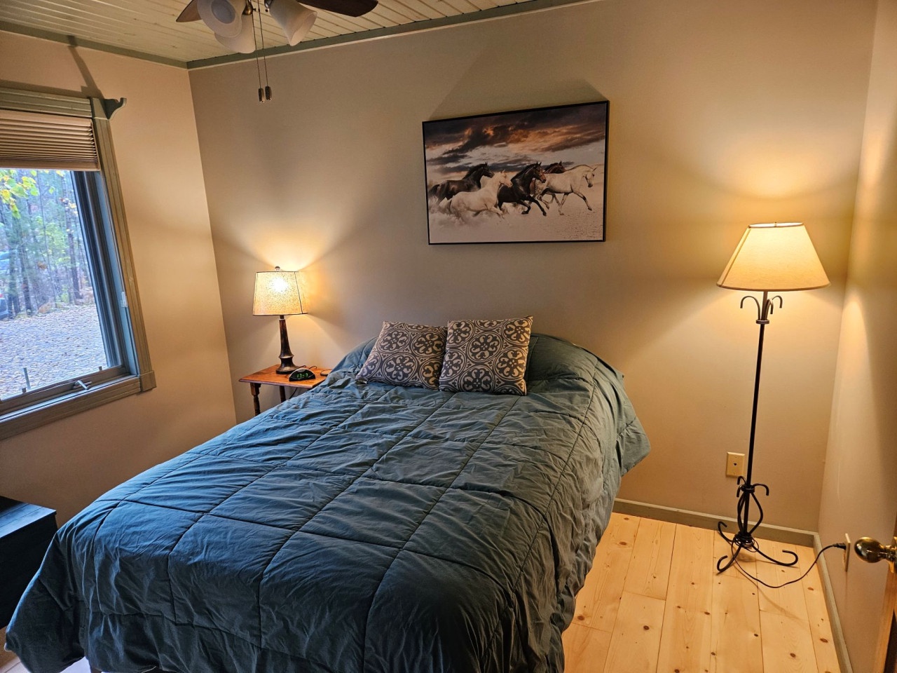 Drift off in your cozy bedroom with warm lighting, comfortable bedding, and peaceful forest views.