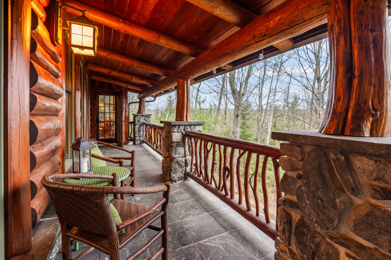 Unwind in your private covered porch, where rustic log beams frame peaceful forest views and cozy seating invites morning coffee moments.
