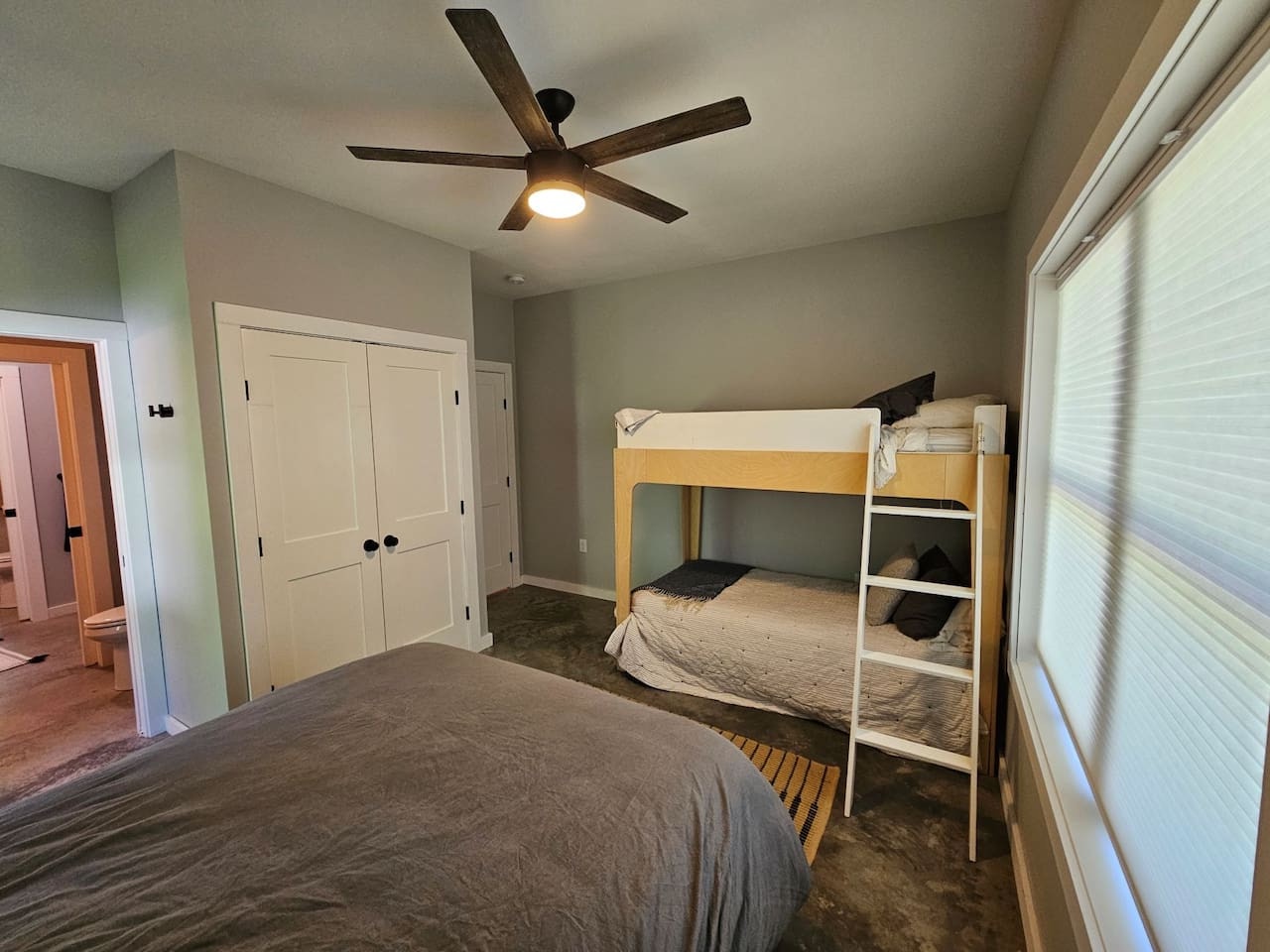 Sleep comfortably in this thoughtfully designed bedroom featuring a queen bed and bunk beds, perfect for families or groups seeking flexible sleeping arrangements.