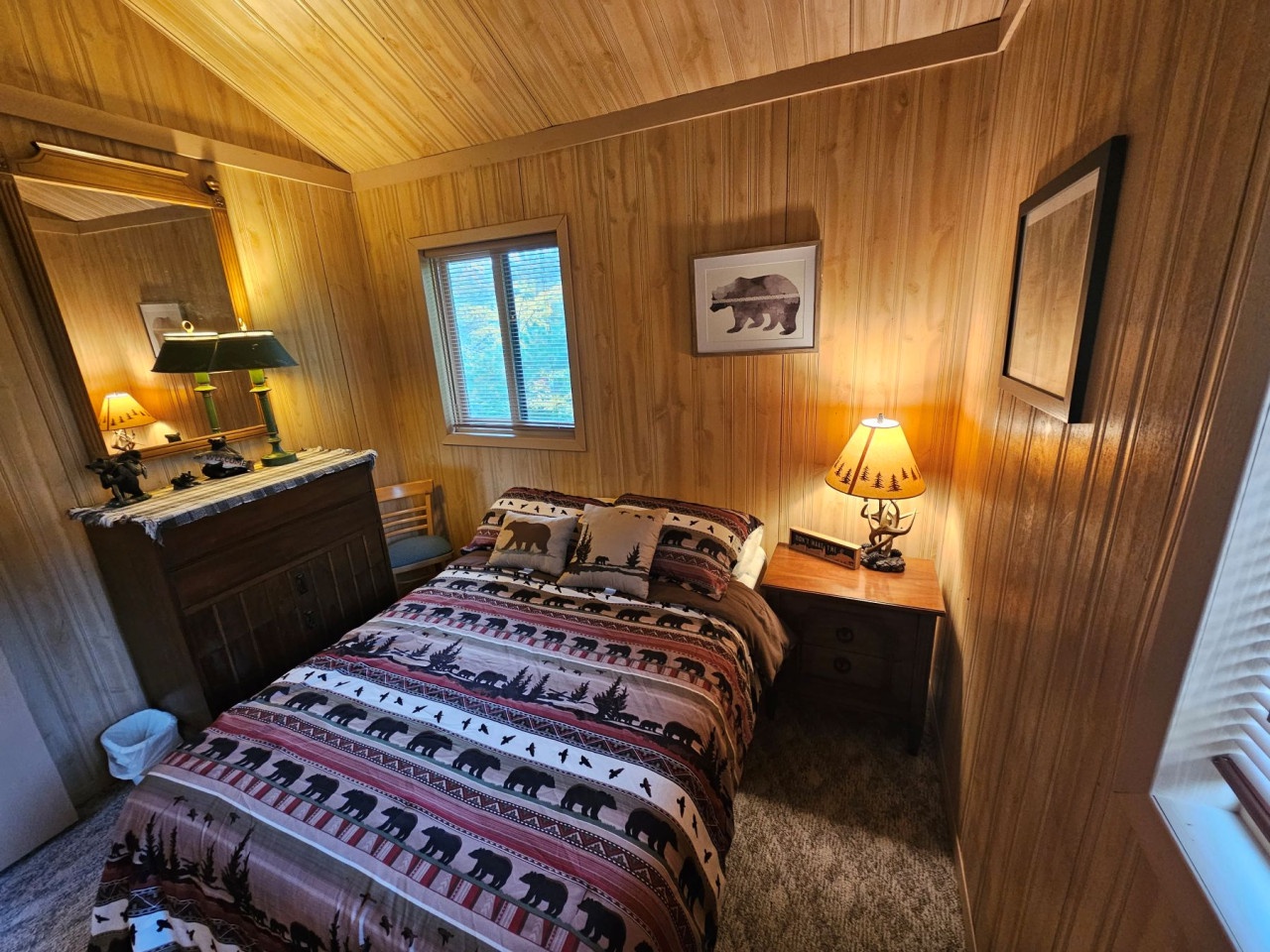 Cozy cabin bedroom with rustic bear-themed bedding wraps you in woodland charm, perfect for restful mountain retreats.