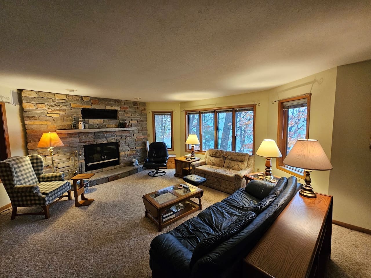 Sink into plush leather seating by your cozy stone fireplace while enjoying forest views through large windows.