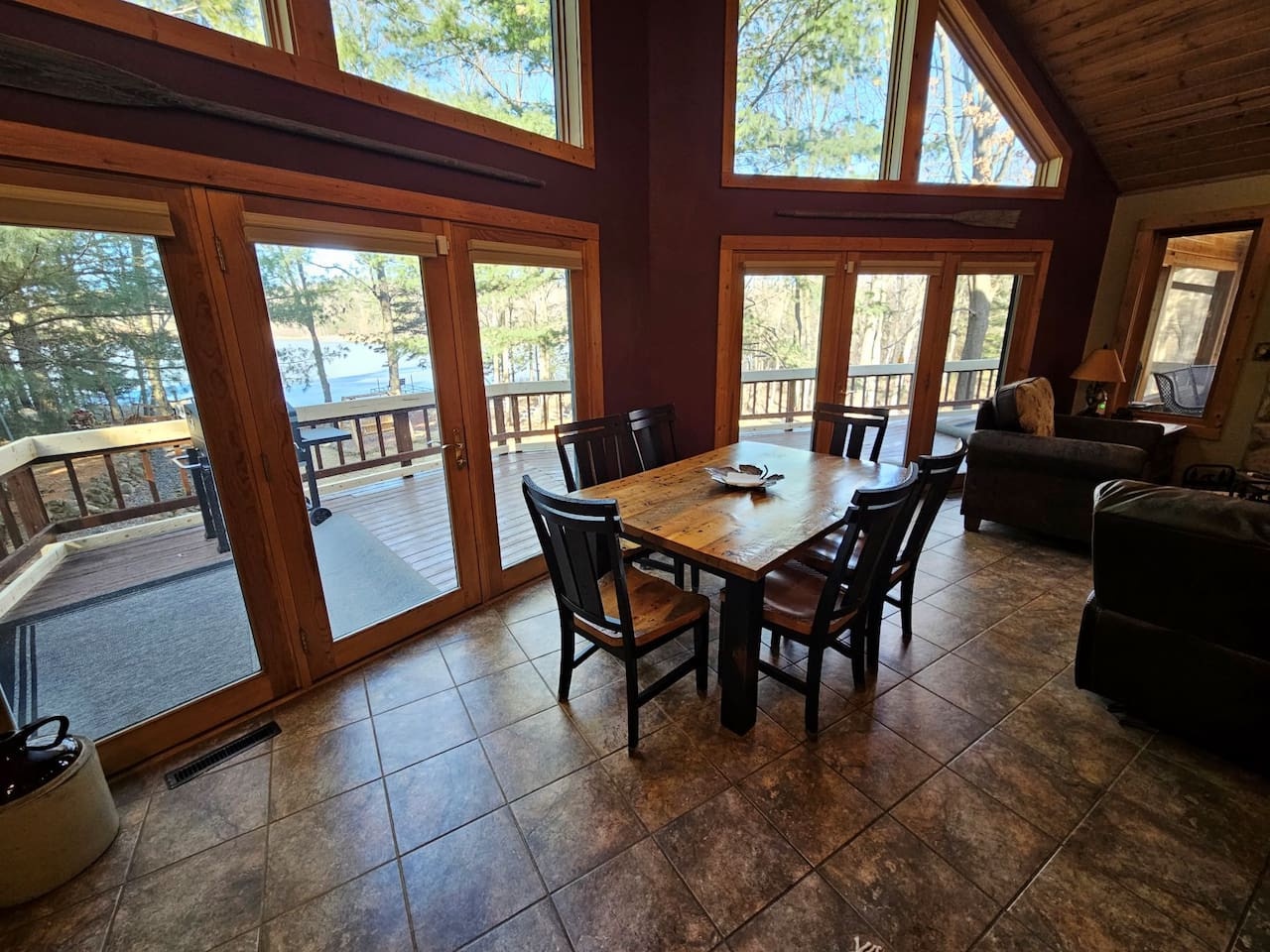 Your cozy dining space opens to stunning lake views through floor-to-ceiling windows, perfect for morning coffee or evening meals with nature as your backdrop.