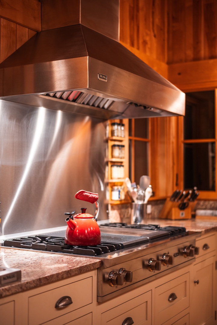 Your gourmet kitchen awaits with professional-grade appliances and warm wood cabinetry, perfect for creating memorable meals during your stay.
