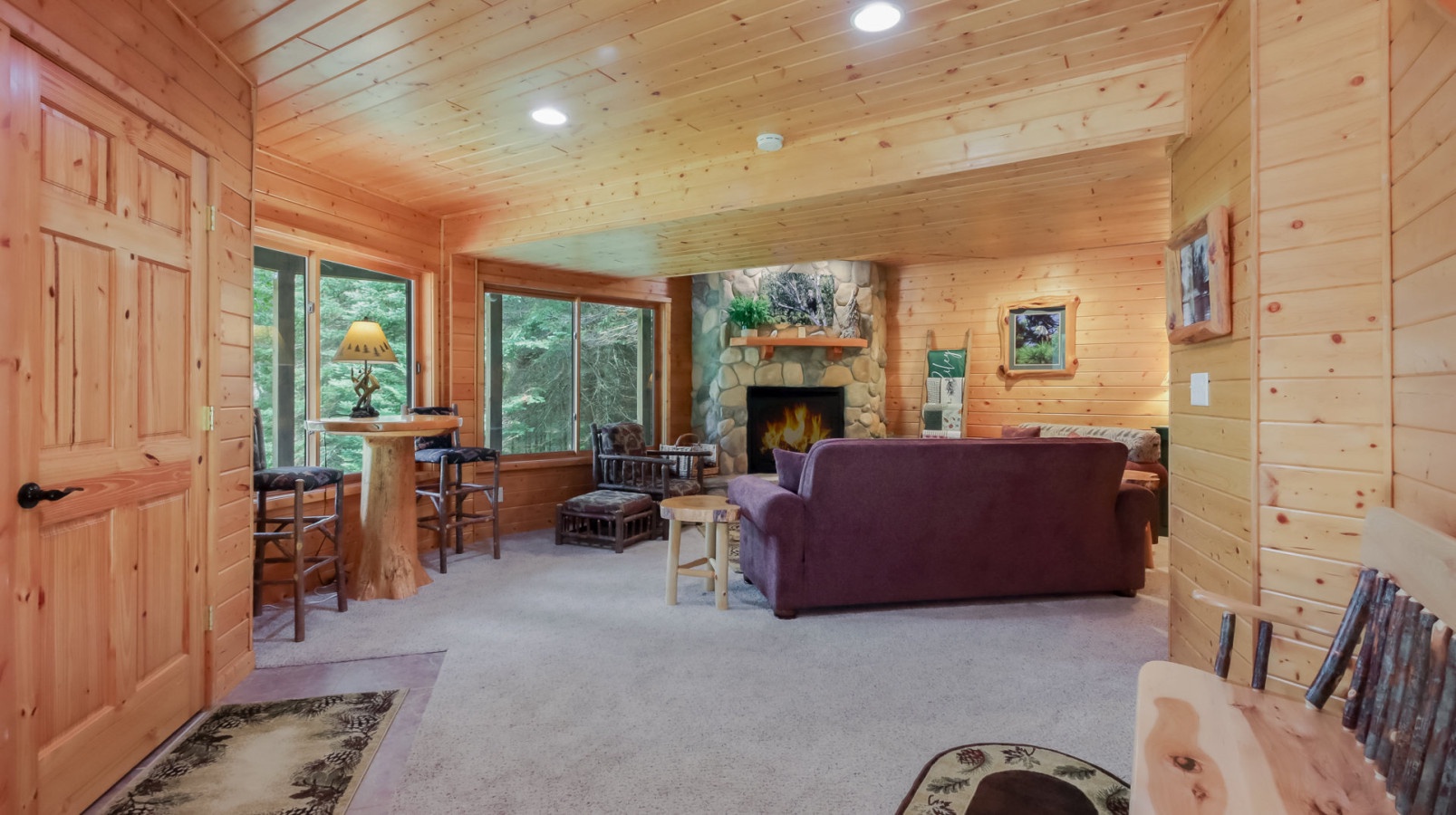 Cozy up by the stone fireplace in this warm pine cabin retreat, where rustic charm meets modern comfort for your mountain getaway.