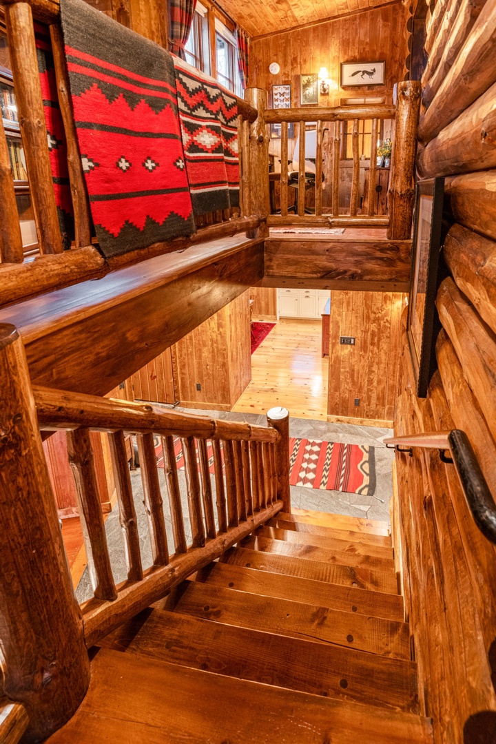 Rich wood surrounds you in this cozy cabin stairway, where Native American textiles add warmth to your mountain retreat.