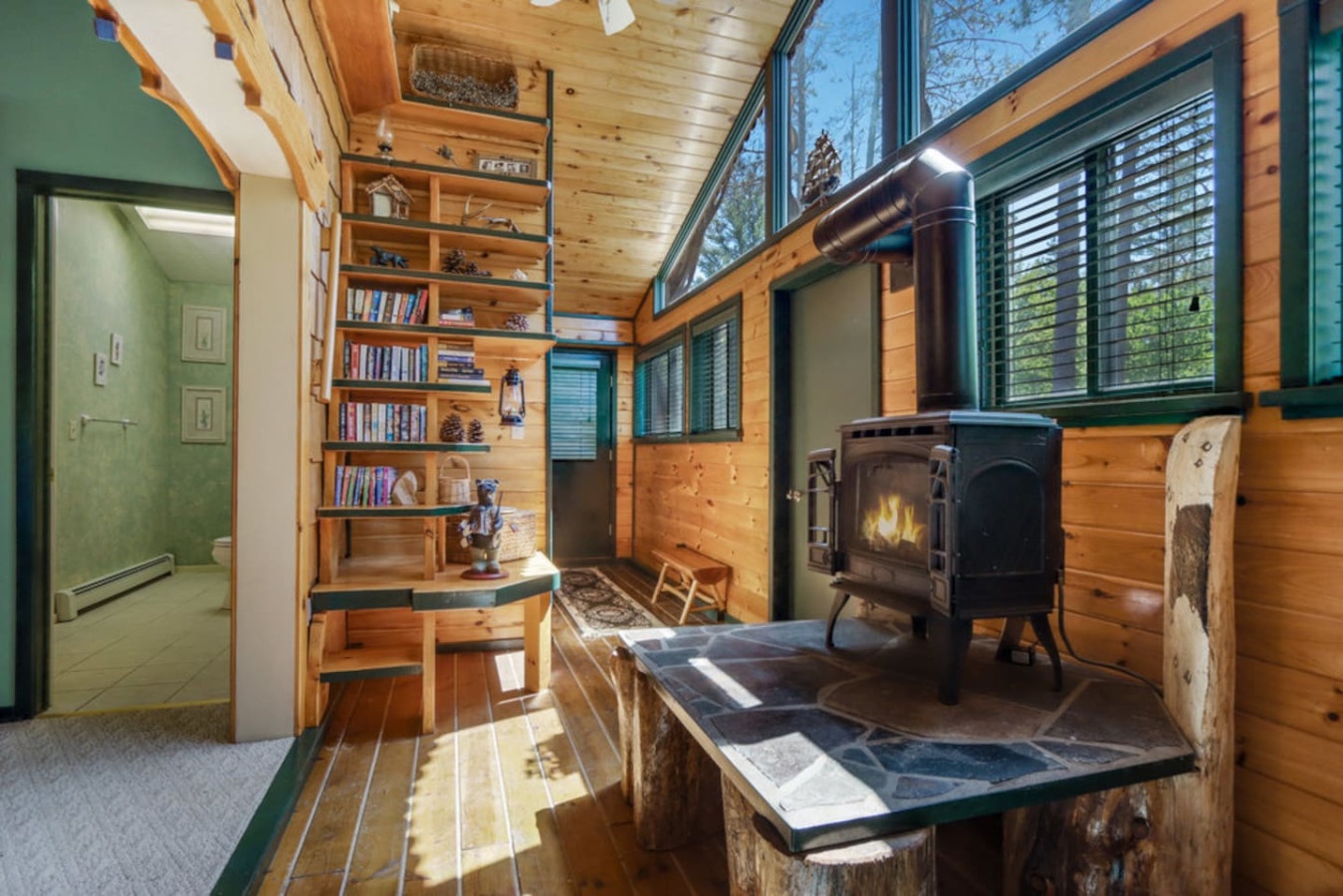 Cozy up in your rustic retreat with a crackling wood-burning stove, built-in library, and warm natural light streaming through generous windows.
