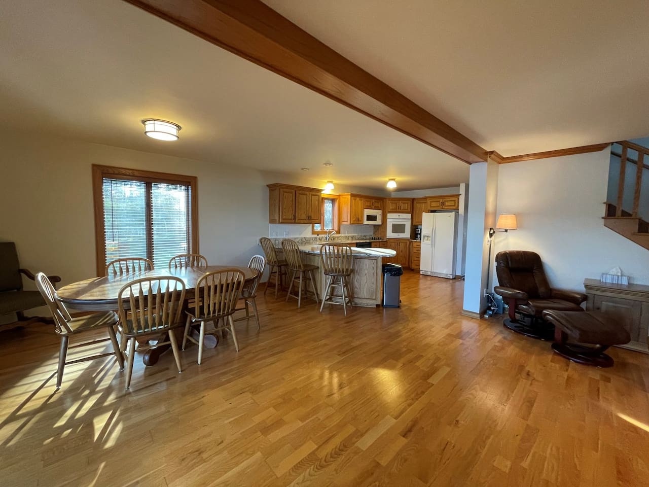 Unwind in your spacious open-plan retreat with gleaming hardwood floors, rustic ceiling beams, and a full kitchen ready for your culinary adventures.