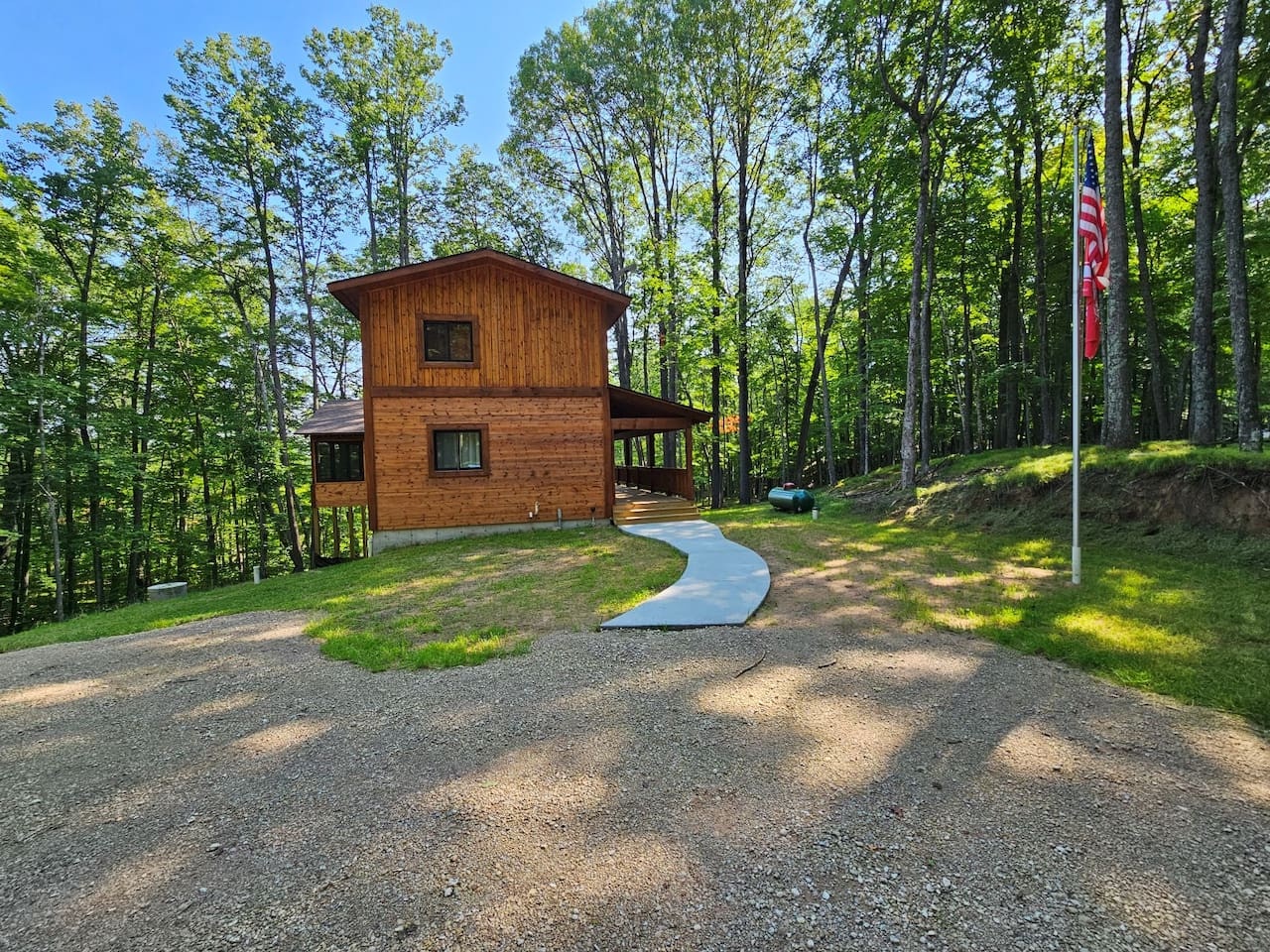 Secluded wooden cabin nestled among towering trees with convenient parking and peaceful forest surroundings.