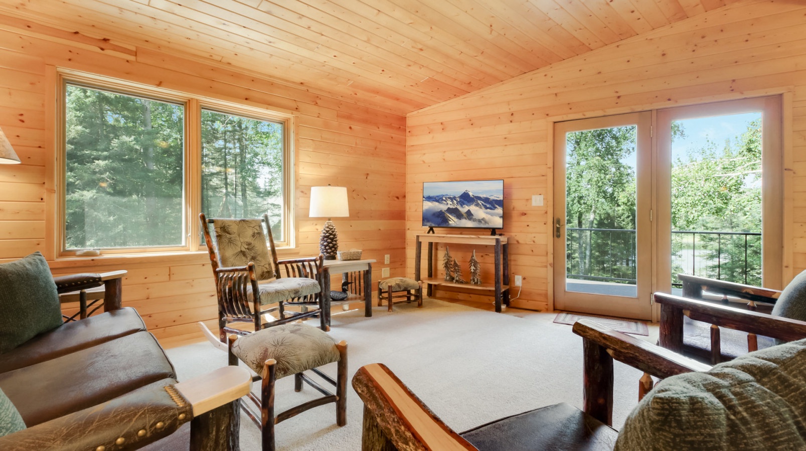 Unwind in your cozy log cabin living room, where rustic charm meets modern comfort with forest views from every window.