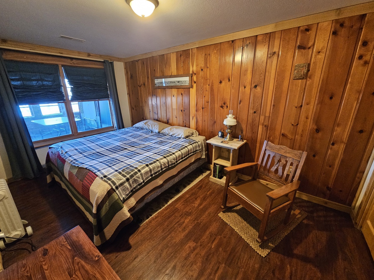 Step into your cozy cabin bedroom with warm wood paneling, vintage quilts, and rustic charm that wraps around you like a peaceful retreat.