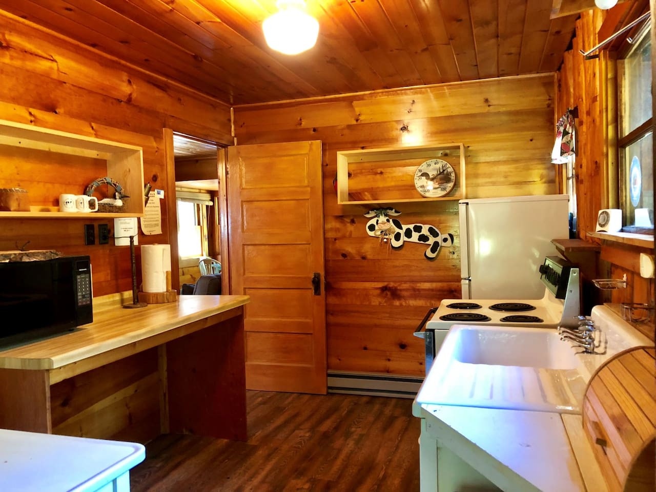 Your cozy log cabin kitchen features rich pine walls, full appliances, and charming rustic touches for memorable mountain meals.
