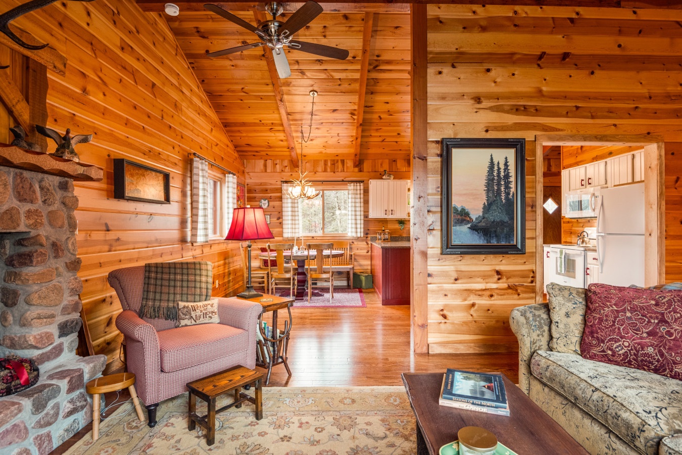 Cozy cabin living where rustic charm meets comfort. Warm wood surrounds you while the stone fireplace beckons for evening relaxation.