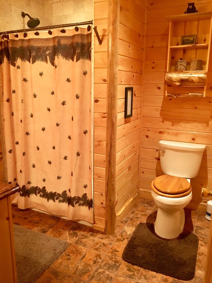 Step into your rustic cabin bathroom where warm wood walls and nature-themed touches create a cozy mountain retreat atmosphere.