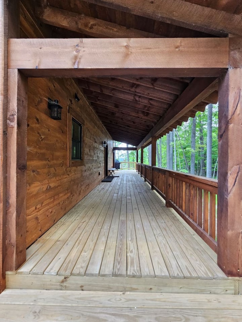 Step onto your private covered balcony where rustic wood beams frame forest views, creating the perfect spot to unwind.