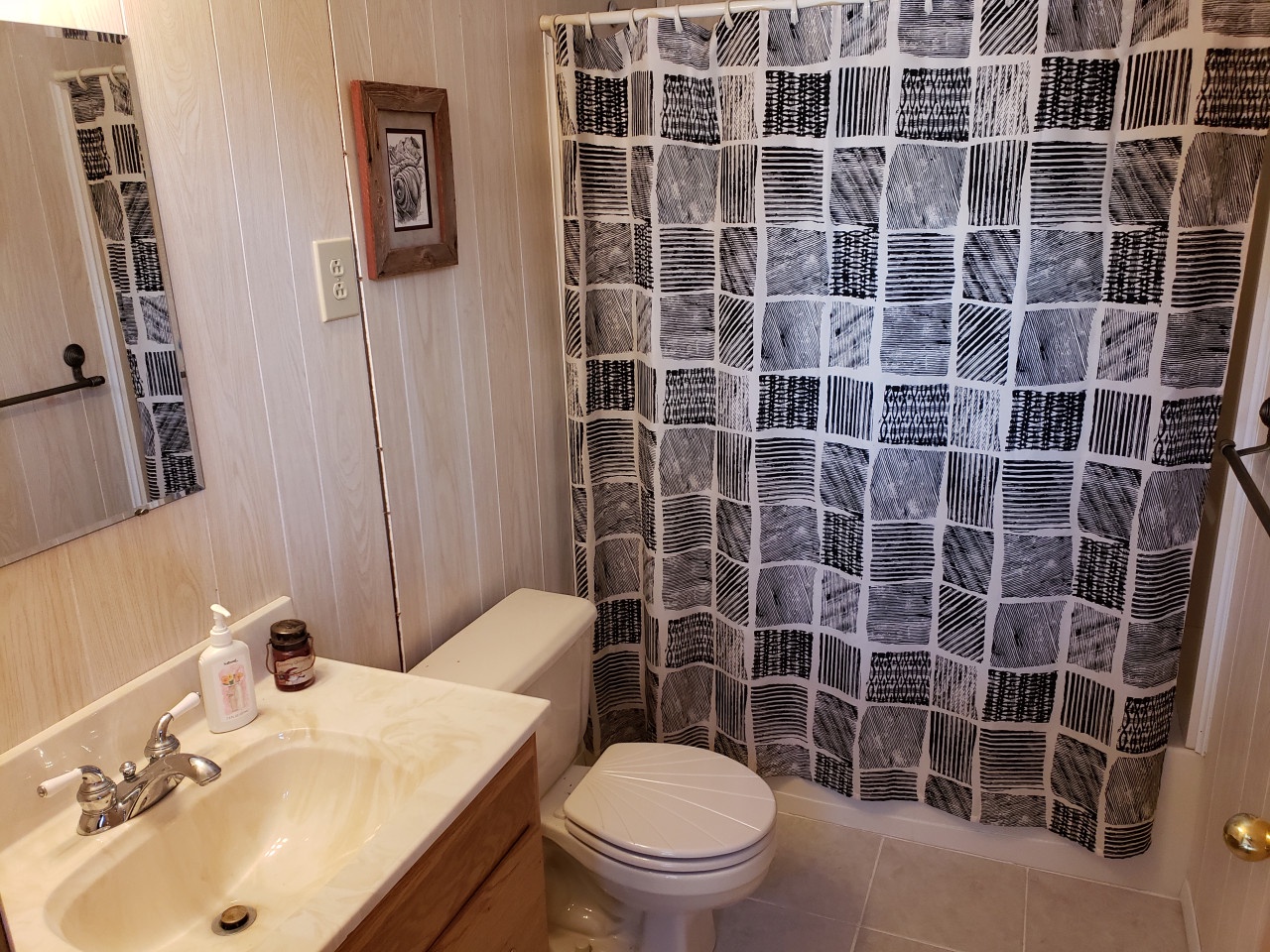 Step into your private bathroom with shower-tub combo, artistic patterned curtain, and thoughtful amenities for a refreshing start to your day.