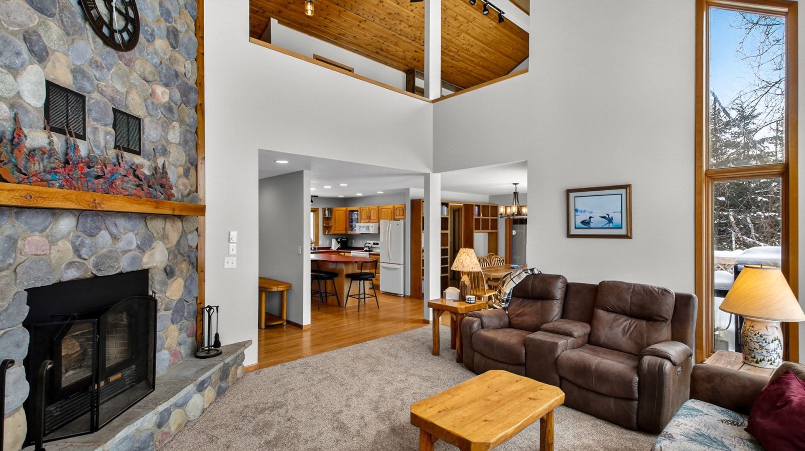 Relax in your spacious living room with soaring ceilings, cozy stone fireplace, and leather seating that invites long conversations.