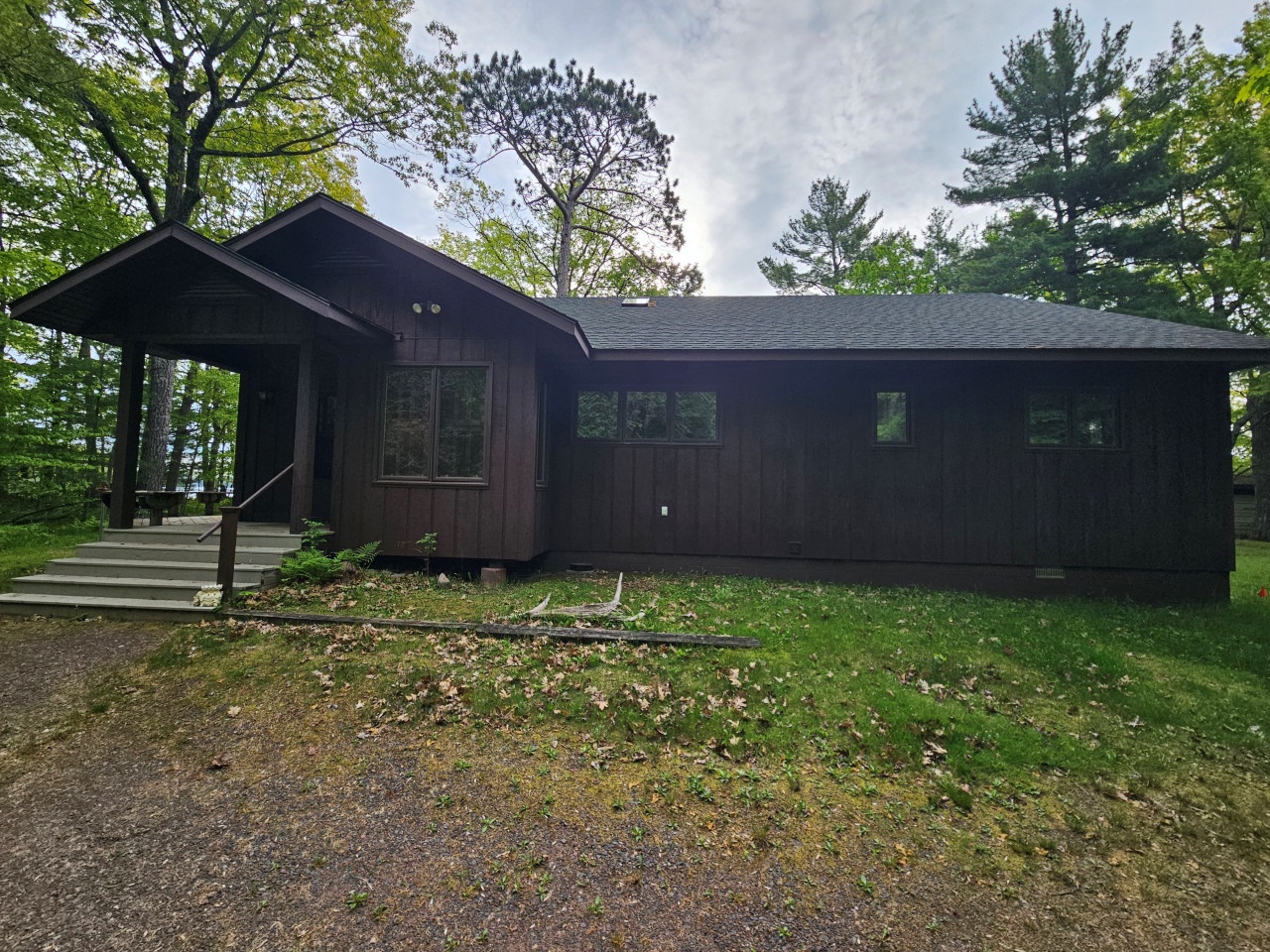 A secluded cabin nestled among towering trees, offering a peaceful forest retreat with modern comfort and natural charm.