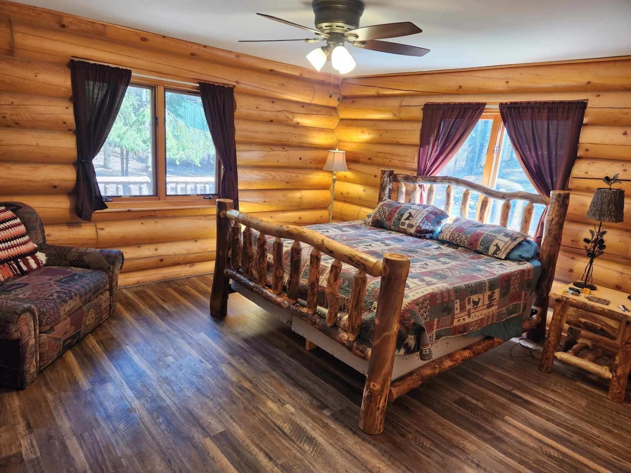Your cozy log cabin bedroom features handcrafted rustic furniture and warm wood walls that create the perfect mountain retreat atmosphere.