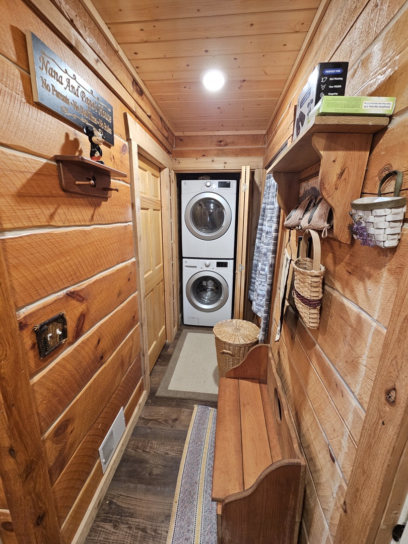 Your rustic laundry space combines alpine charm with modern convenience, featuring stacked machines and thoughtful storage throughout.