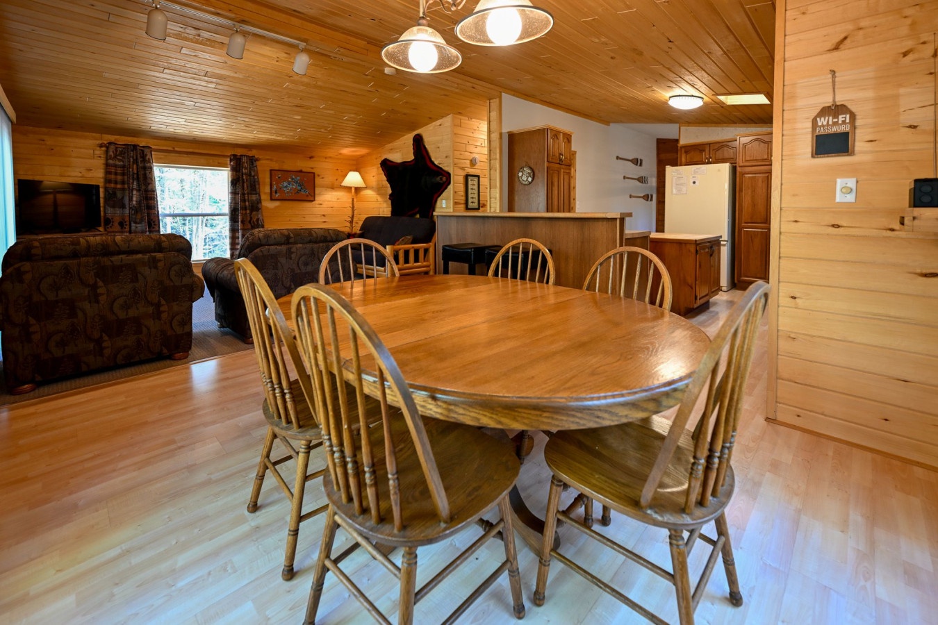 Gather around this spacious dining table for memorable meals with your loved ones in this warm, wood-paneled retreat.