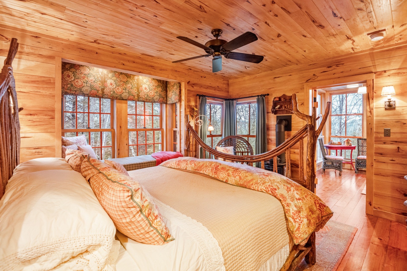 Snuggle into your rustic bedroom sanctuary where autumn views frame your king bed and a crackling fireplace awaits cozy evenings.