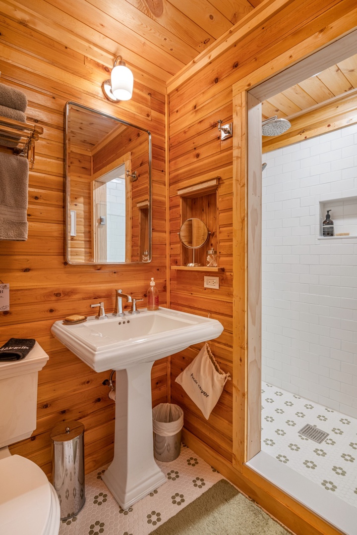Step into your rustic retreat bathroom where warm wood walls create a cozy cabin atmosphere for your refreshing morning routine.