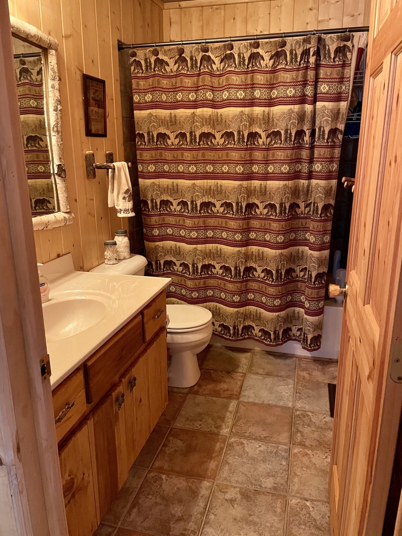 Unwind in your rustic cabin bathroom featuring warm wood paneling and charming bear-themed touches that make every shower feel like a woodland retreat.