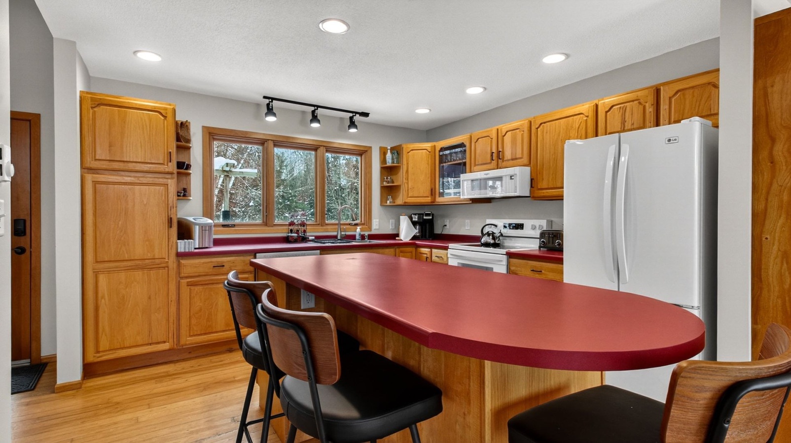Your spacious kitchen features warm wood cabinets, modern appliances, and a breakfast bar where you'll enjoy morning coffee.