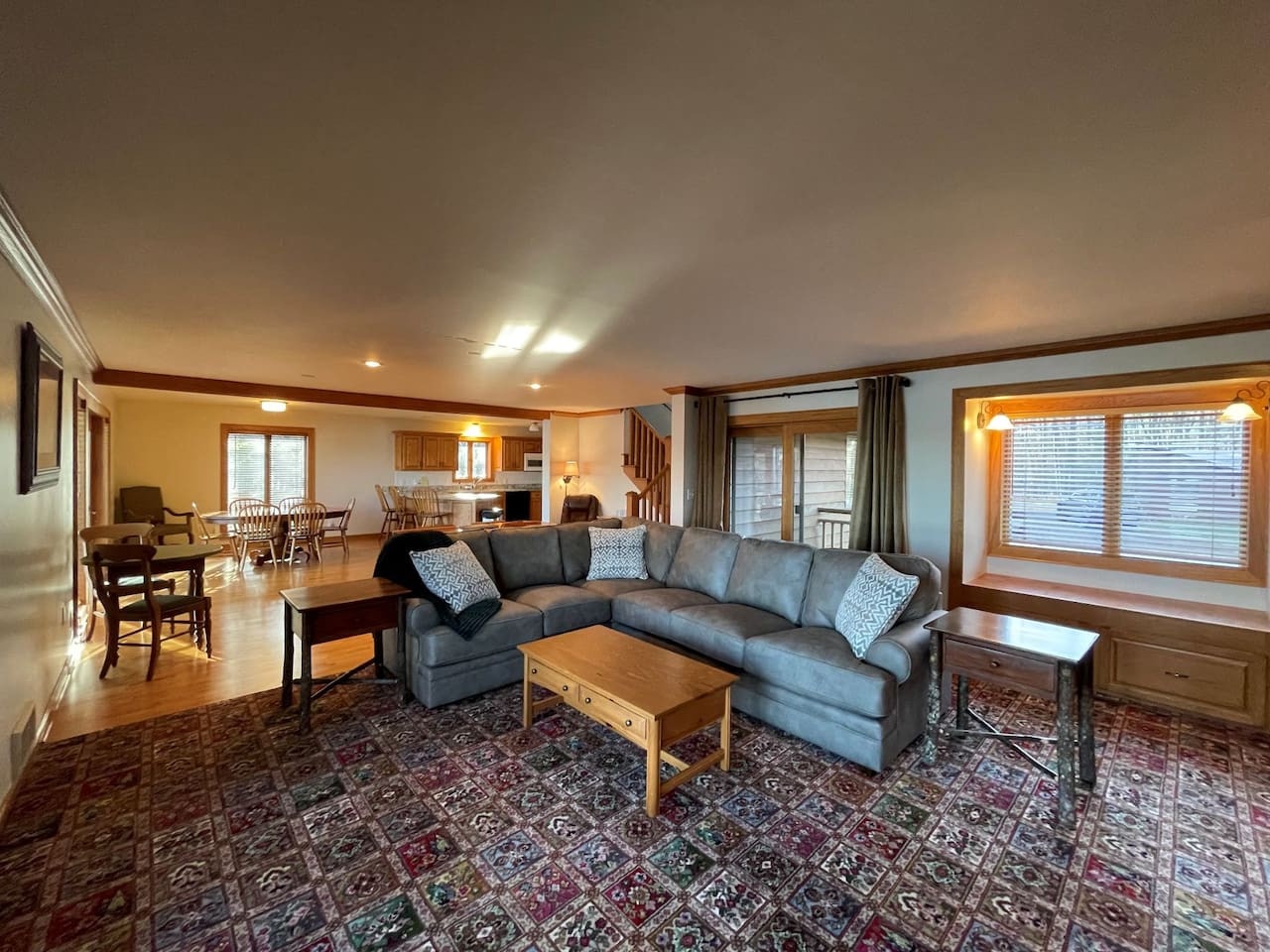 Settle into your spacious open-concept living space where plush sectional seating and warm wood accents create the perfect gathering spot for memorable evenings.