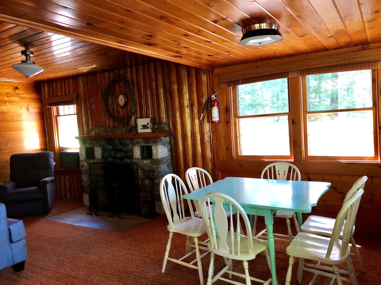 Gather around your spacious dining table for meals and games, warmed by the cozy stone fireplace in this rustic cabin retreat.