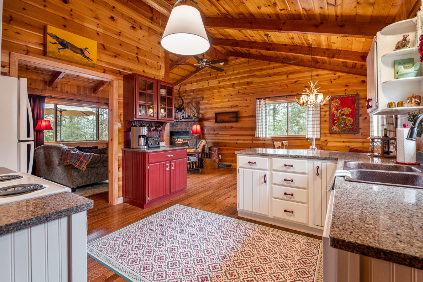 Step into your rustic yet modern kitchen where warm wood beams frame granite countertops and charming details create the perfect mountain retreat atmosphere.