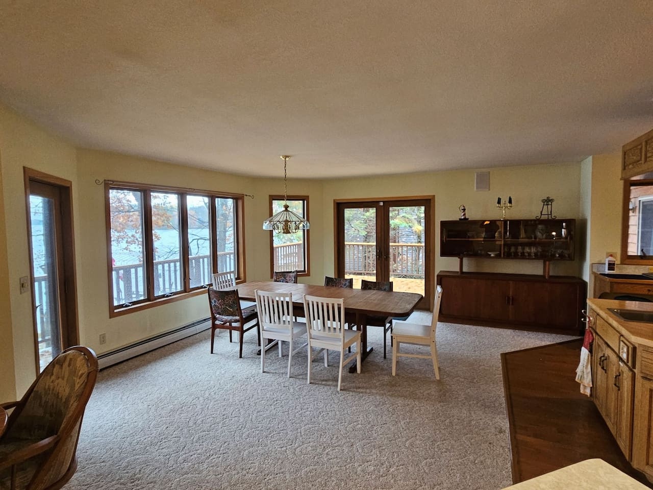 Gather around your spacious dining table as natural light streams through windows framing peaceful wooded views and deck access.