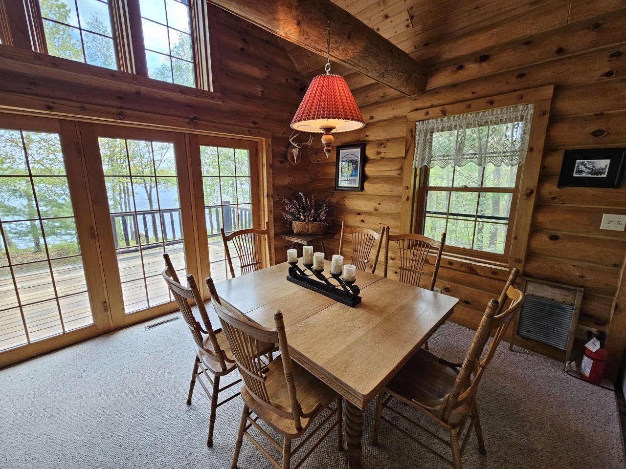 Gather around this rustic dining table where your group can share meals with warm wood surroundings and peaceful lake views through every window.
