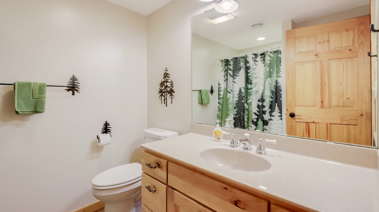 Refresh in your cozy pine-themed bathroom with natural wood vanity, forest-inspired décor, and soft green accents creating a peaceful mountain retreat atmosphere.